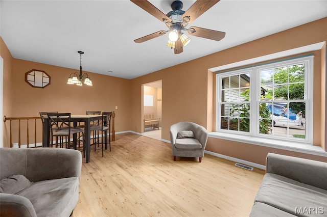 205 Fawn Meadow Ct, Ofallon, MO 63366 - living room with light wood finished floors, a chandelier, and a ceiling fan