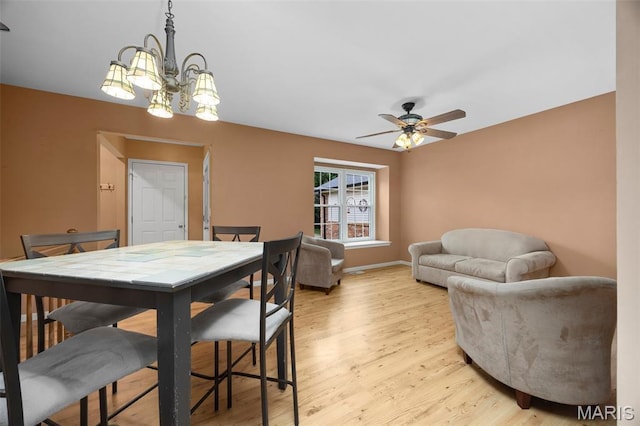 205 Fawn Meadow Ct, Ofallon, MO 63366 - dining room with light wood-type flooring, ceiling fan, and a chandelier