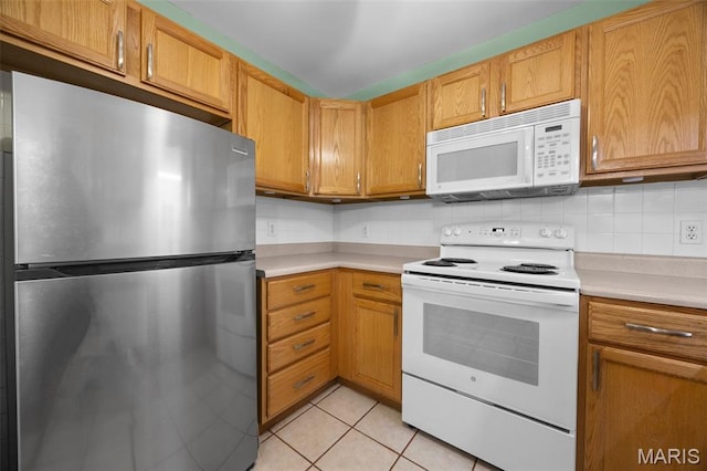 205 Fawn Meadow Ct, Ofallon, MO 63366 - kitchen with white appliances, light countertops, light tile patterned floors, and brown cabinetry