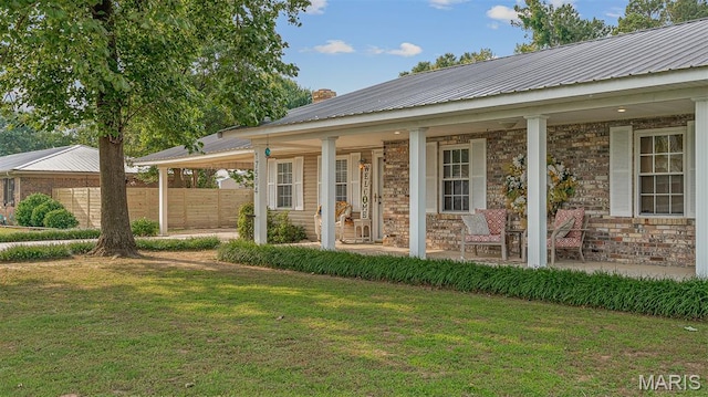 17504 Division St, Kennett, MO 63857 - entrance to property featuring covered porch, metal roof, stone siding, and a chimney