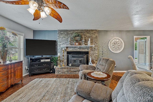 17504 Division St, Kennett, MO 63857 - living area with ceiling fan, wood finished floors, baseboards, a textured ceiling, and a brick fireplace