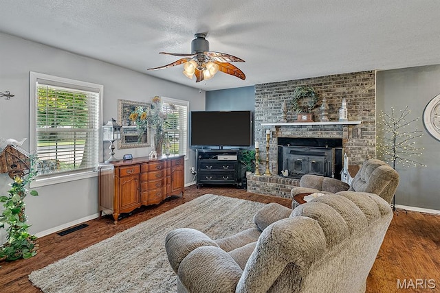 17504 Division St, Kennett, MO 63857 - living area with a ceiling fan, a textured ceiling, baseboards, a brick fireplace, and wood finished floors