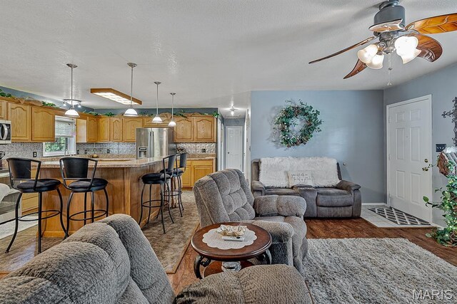 17504 Division St, Kennett, MO 63857 - living room with a ceiling fan, wood finished floors, and baseboards