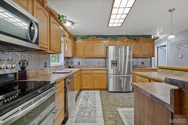 17504 Division St, Kennett, MO 63857 - kitchen featuring stainless steel appliances, a sink, tasteful backsplash, and decorative light fixtures