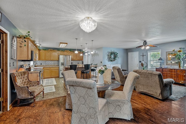 17504 Division St, Kennett, MO 63857 - dining room featuring wood finished floors, a chandelier, ceiling fan, and a textured ceiling