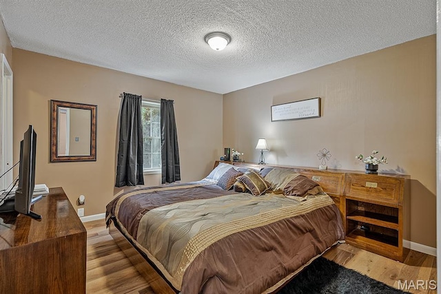 17504 Division St, Kennett, MO 63857 - bedroom featuring wood finished floors, baseboards, and a textured ceiling