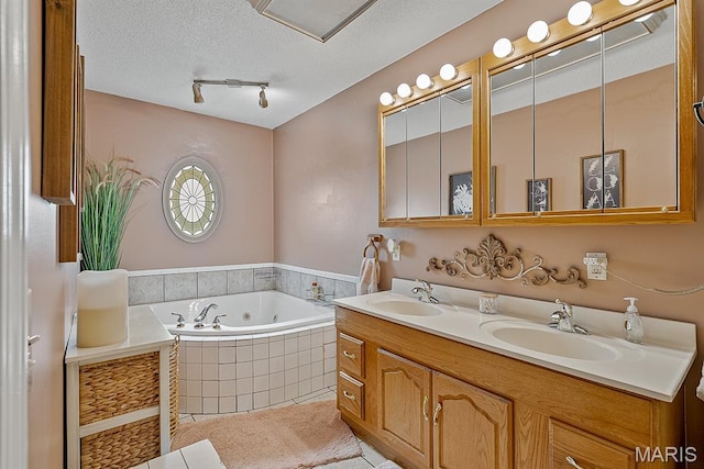 17504 Division St, Kennett, MO 63857 - bathroom featuring double vanity, a tub with jets, a textured ceiling, tile patterned floors, and rail lighting