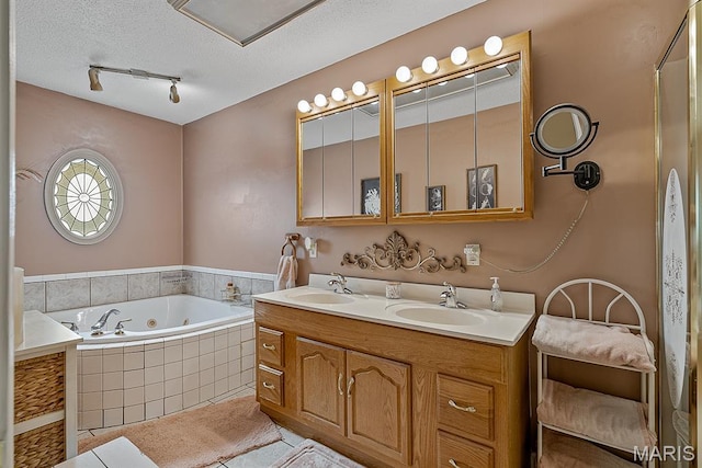 17504 Division St, Kennett, MO 63857 - bathroom featuring a jetted tub, double vanity, a textured ceiling, track lighting, and tile patterned floors