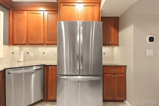 6620 Lake Point Dr Unit 26, Osage Beach, MO 65065 - kitchen featuring stainless steel appliances, tasteful backsplash, light stone counters, and brown cabinets