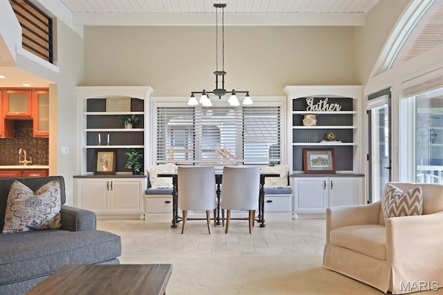 6620 Lake Point Dr Unit 26, Osage Beach, MO 65065 - living room featuring a chandelier, a towering ceiling, and light tile patterned floors