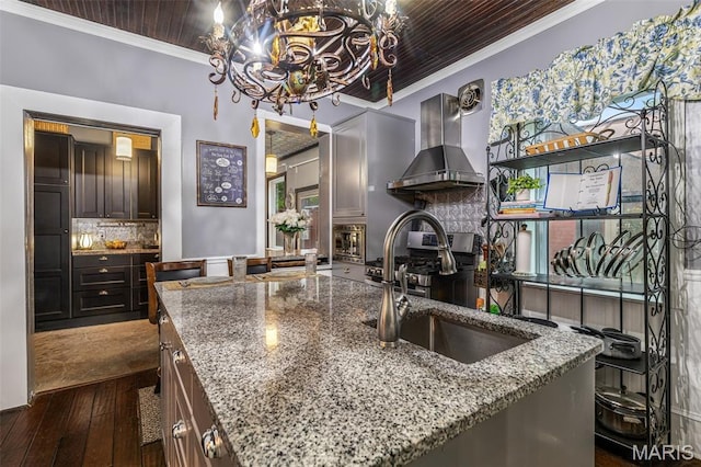 698N 3rd St, Saint Genevieve, MO 63670 - kitchen featuring wall chimney exhaust hood, ornamental molding, a chandelier, dark wood-type flooring, and light stone counters