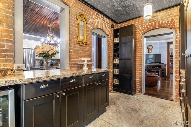 698N 3rd St, Saint Genevieve, MO 63670 - bar with beverage cooler, brick wall, an ornate ceiling, a chandelier, and light colored carpet
