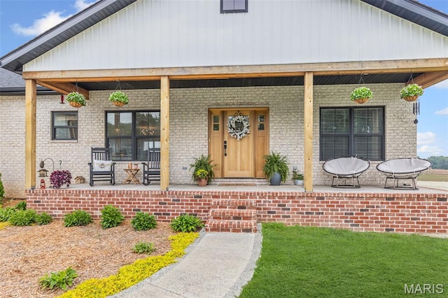 8353 Maple Grove Rd, Troy, IL 62294 - view of exterior entry with covered porch, brick siding, and board and batten siding