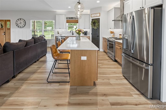 8353 Maple Grove Rd, Troy, IL 62294 - kitchen with stainless steel appliances, open floor plan, light wood finished floors, a breakfast bar, and light countertops