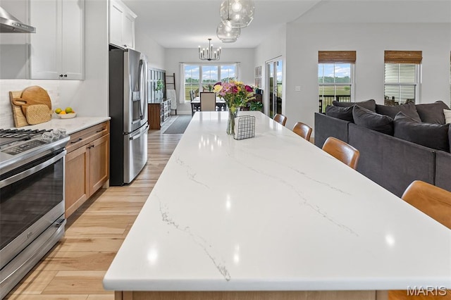 8353 Maple Grove Rd, Troy, IL 62294 - kitchen featuring stainless steel appliances, wall chimney range hood, light wood finished floors, open floor plan, and a large island