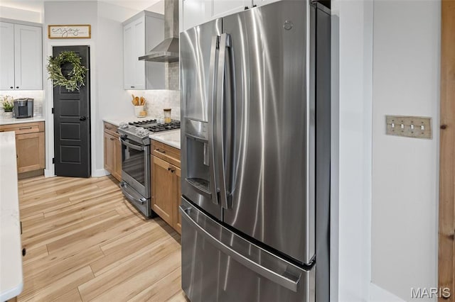 8353 Maple Grove Rd, Troy, IL 62294 - kitchen with stainless steel appliances, wall chimney exhaust hood, light wood finished floors, and backsplash