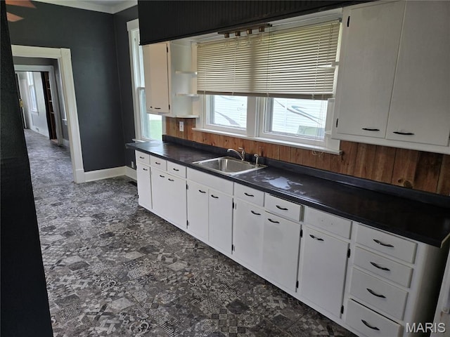 107 N 18th St, Belleville, IL 62226 - kitchen with dark countertops, a sink, white cabinets, and baseboards