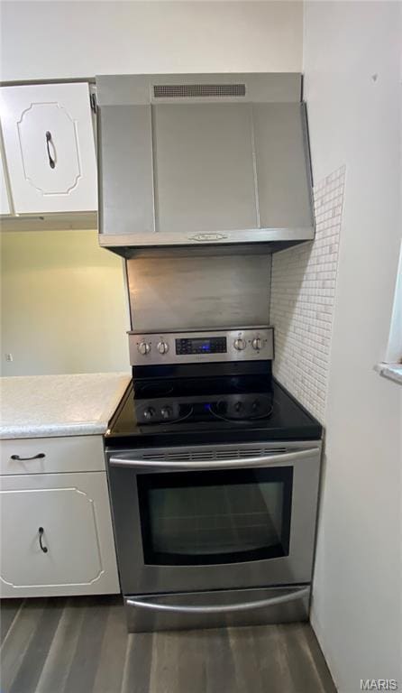 3122 Carnaby Ln Unit C, Bridgeton, MO 63044 - kitchen with stainless steel electric range, dark wood-style floors, light countertops, and white cabinetry
