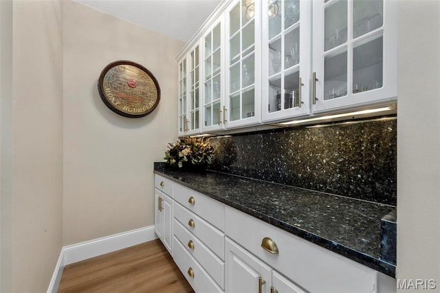 1315 Wildhorse Meadows Dr, Chesterfield, MO 63005 - bar area with light wood-style floors, baseboards, and tasteful backsplash