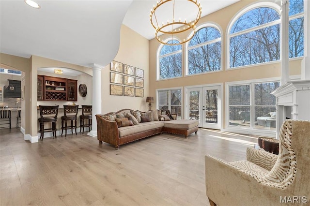 1315 Wildhorse Meadows Dr, Chesterfield, MO 63005 - living room with a towering ceiling, wood finished floors, ornate columns, a chandelier, and recessed lighting