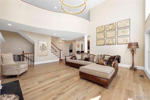 1315 Wildhorse Meadows Dr, Chesterfield, MO 63005 - living area featuring light wood finished floors, decorative columns, arched walkways, baseboards, and a high ceiling