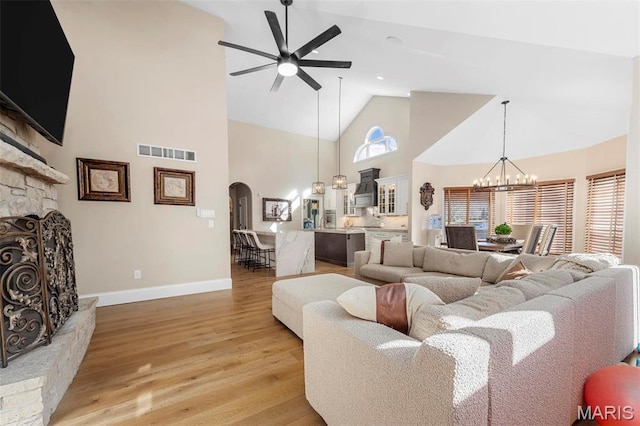 1315 Wildhorse Meadows Dr, Chesterfield, MO 63005 - living room featuring a ceiling fan, a chandelier, high vaulted ceiling, arched walkways, and light wood finished floors