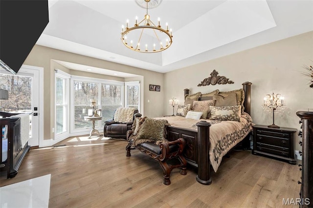 1315 Wildhorse Meadows Dr, Chesterfield, MO 63005 - bedroom featuring a chandelier, wood finished floors, a tray ceiling, and access to outside