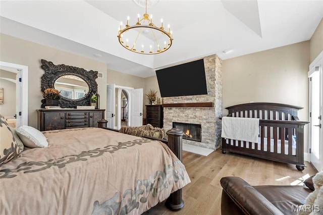 1315 Wildhorse Meadows Dr, Chesterfield, MO 63005 - bedroom featuring a chandelier, wood finished floors, and a fireplace