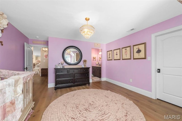 1315 Wildhorse Meadows Dr, Chesterfield, MO 63005 - bedroom featuring a chandelier, wood finished floors, baseboards, and connected bathroom