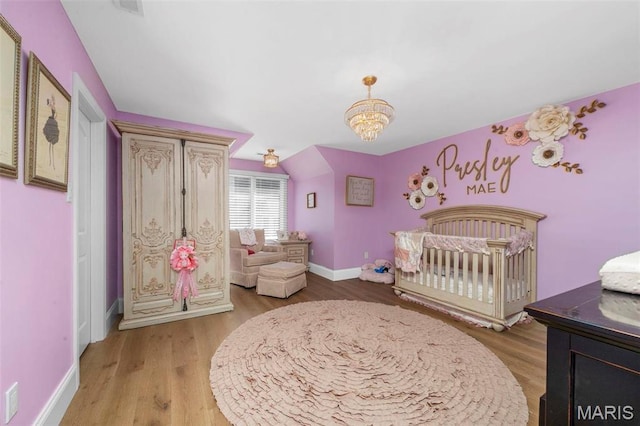 1315 Wildhorse Meadows Dr, Chesterfield, MO 63005 - bedroom with wood finished floors, a chandelier, baseboards, and a crib