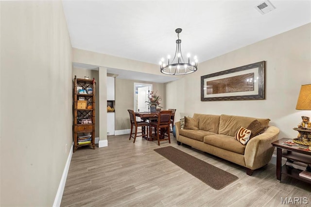 1315 Wildhorse Meadows Dr, Chesterfield, MO 63005 - living area featuring a chandelier, baseboards, and light wood-type flooring