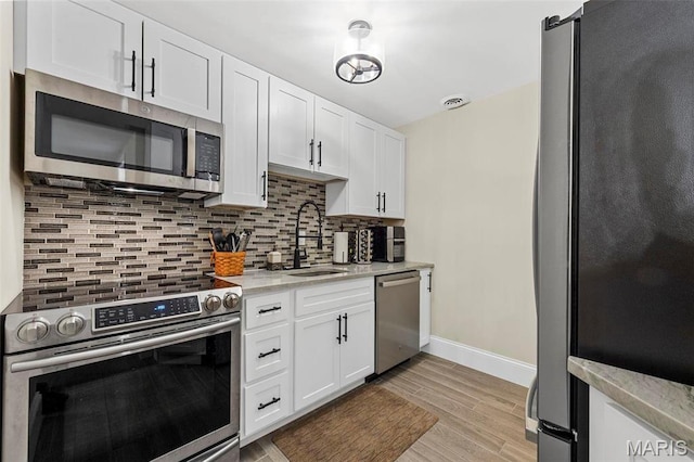 1315 Wildhorse Meadows Dr, Chesterfield, MO 63005 - kitchen featuring stainless steel appliances, a sink, decorative backsplash, baseboards, and white cabinets