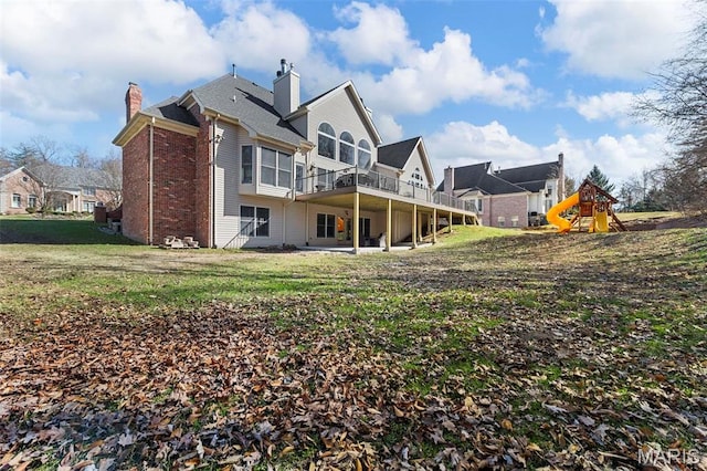 1315 Wildhorse Meadows Dr, Chesterfield, MO 63005 - back of property featuring a chimney, a lawn, a playground, brick siding, and a deck