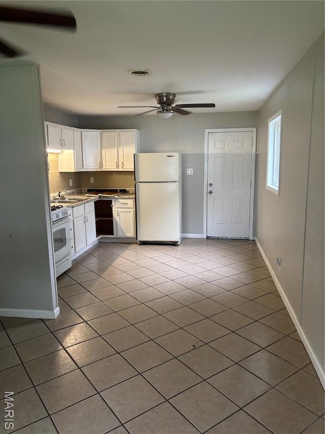 35 Saint Justin Dr E, St Louis, IL 62206 - kitchen with white appliances, a ceiling fan, light tile patterned flooring, white cabinets, and baseboards