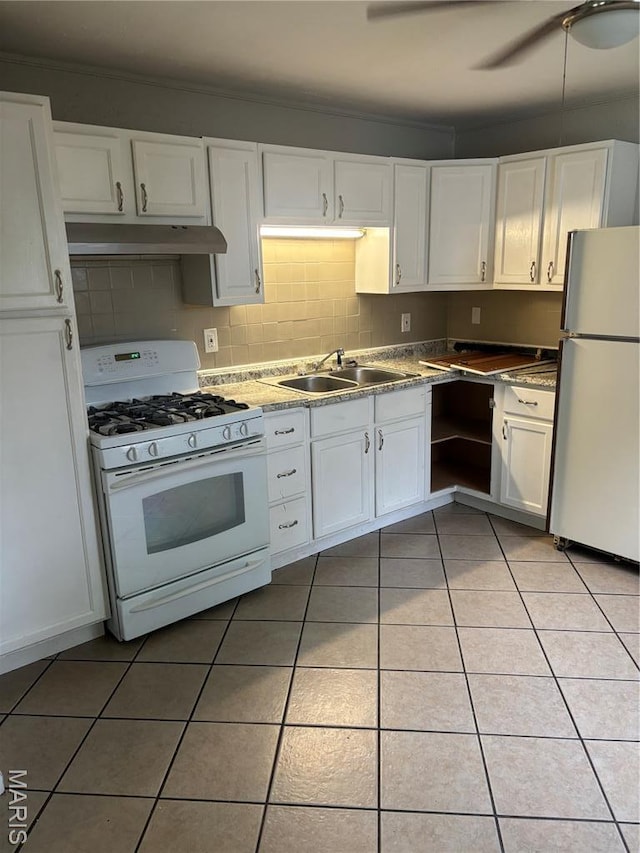 35 Saint Justin Dr E, St Louis, IL 62206 - kitchen featuring freestanding refrigerator, white gas range oven, under cabinet range hood, a sink, and white cabinets