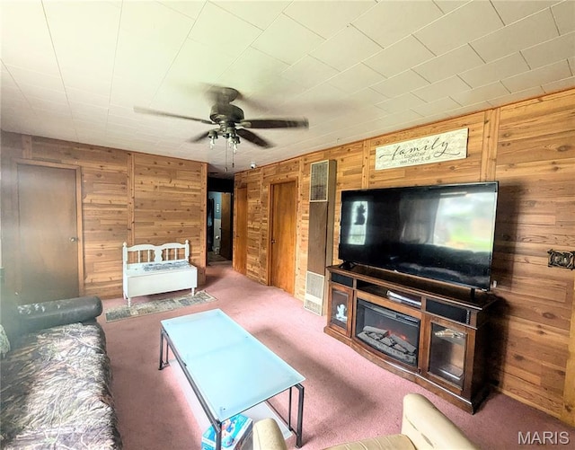 200 N Elm St, Campbell, MO 63933 - living room featuring wood walls, ceiling fan, and carpet