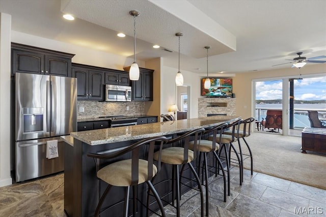 18051 Blue Anchor Dr Unit 533, Gravois Mills, MO 65037 - kitchen featuring stainless steel appliances, open floor plan, backsplash, carpet, and a kitchen bar