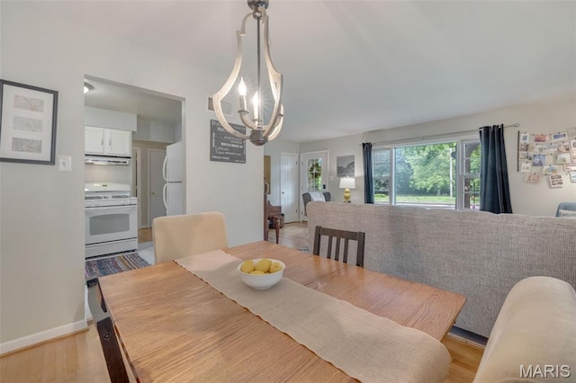 169 W Kirkham Ave, Webster Groves, MO 63119 - dining area with a chandelier and light wood-style flooring
