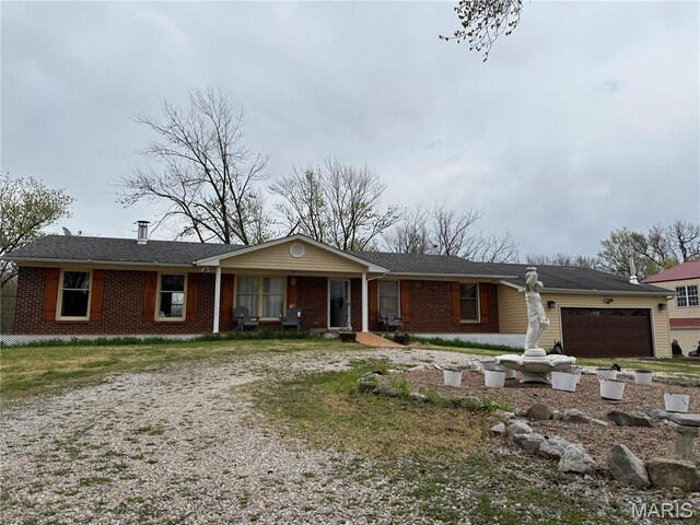 480 N Lindsey Rd, Winfield, MO 63389 - single story home with dirt driveway, a garage, and brick siding
