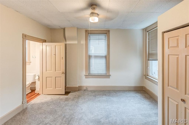 27 N 14th St, Belleville, IL 62220 - unfurnished bedroom with carpet flooring, multiple windows, connected bathroom, and a ceiling fan