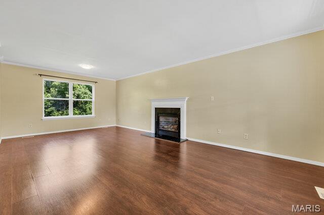 1305 Flintshire Ln, Lake St Louis, MO 63367 - unfurnished living room featuring ornamental molding, dark wood-type flooring, and a high end fireplace