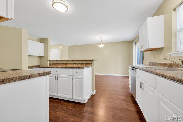 1305 Flintshire Ln, Lake St Louis, MO 63367 - kitchen with dark wood-style floors, stainless steel dishwasher, white cabinetry, hanging light fixtures, and a peninsula