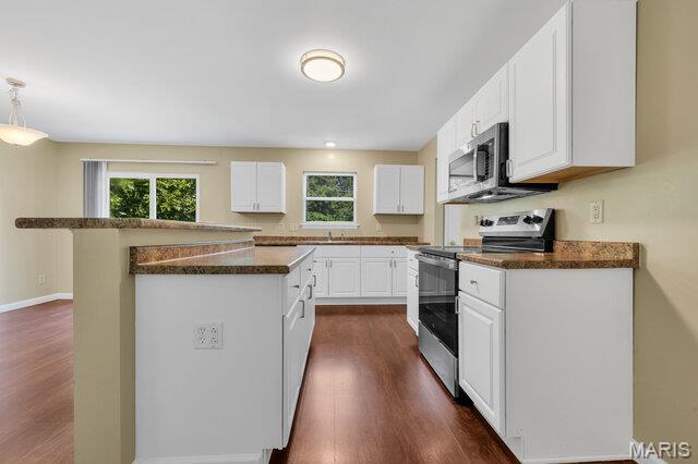 1305 Flintshire Ln, Lake St Louis, MO 63367 - kitchen with appliances with stainless steel finishes, dark wood-type flooring, white cabinets, and a kitchen island