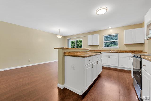 1305 Flintshire Ln, Lake St Louis, MO 63367 - kitchen with stainless steel electric stove, dark wood-style flooring, white cabinets, and dark countertops