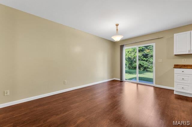 1305 Flintshire Ln, Lake St Louis, MO 63367 - unfurnished dining area featuring dark wood finished floors and baseboards