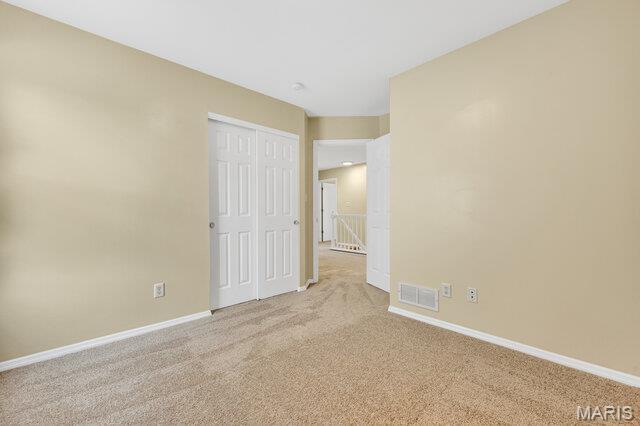 1305 Flintshire Ln, Lake St Louis, MO 63367 - unfurnished bedroom featuring light carpet and a closet