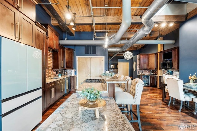 901 Washington Ave Unit 702, Saint Louis, MO 63101 - kitchen with freestanding refrigerator, backsplash, dark wood-style flooring, a sink, and light stone counters