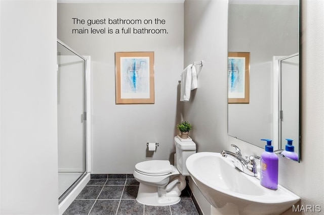 901 Washington Ave Unit 702, Saint Louis, MO 63101 - bathroom featuring toilet, a sink, a stall shower, and tile patterned floors