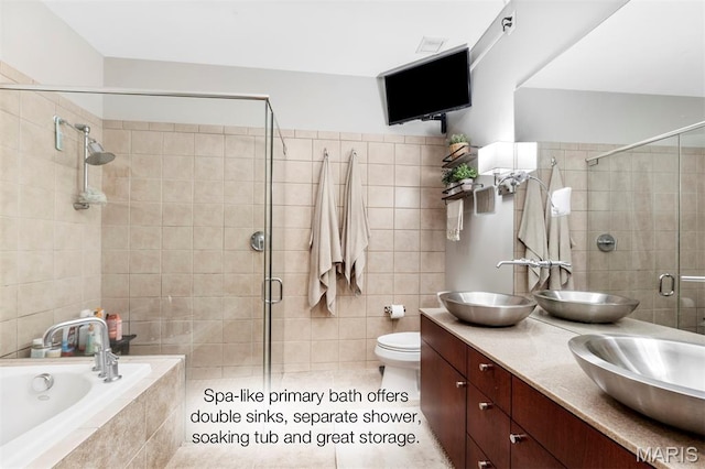 901 Washington Ave Unit 702, Saint Louis, MO 63101 - bathroom with tile walls, a stall shower, double vanity, a bath, and toilet