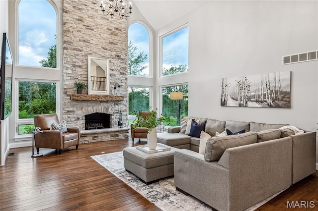 776 Hillenkamp Dr, Weldon Spring, MO 63304 - living room featuring high vaulted ceiling, a chandelier, a stone fireplace, and hardwood / wood-style flooring